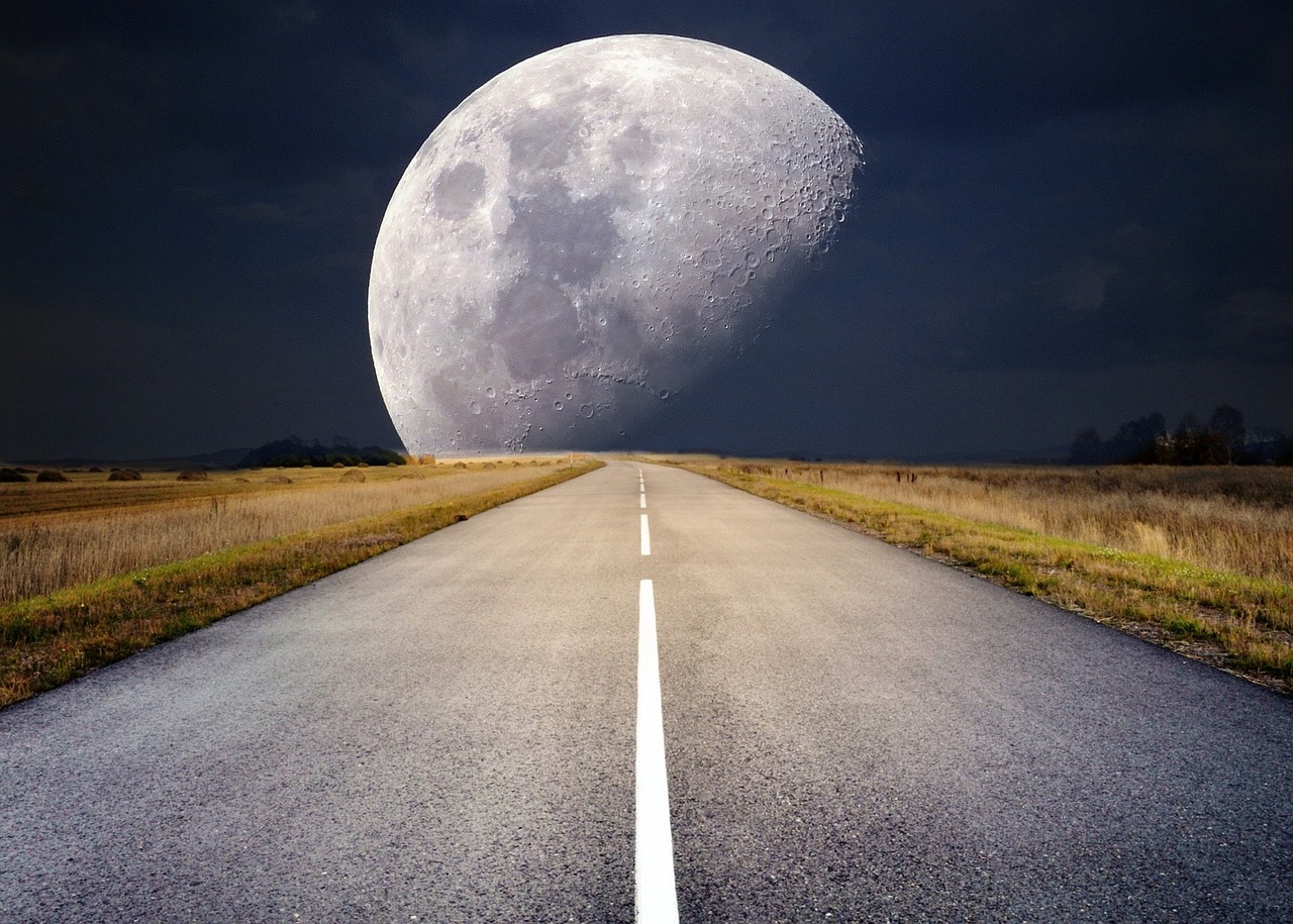 Highway leading to the moon on the horizon