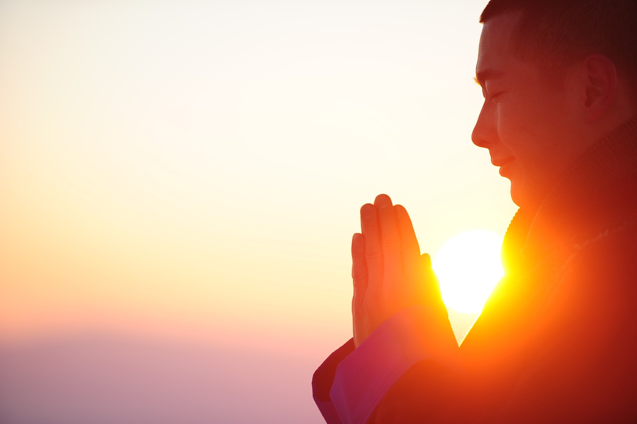 Person praying at sunrise