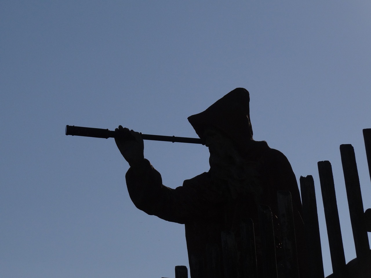 Silhouette of a person looking through a telescope