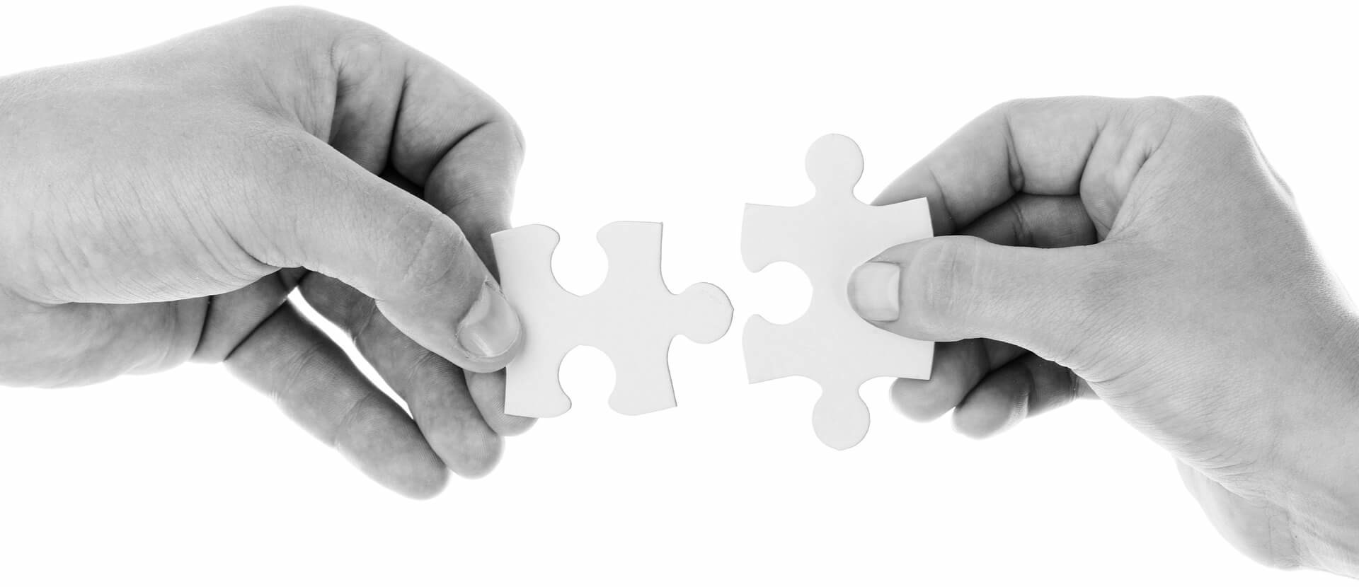Two hands holding a puzzle piece